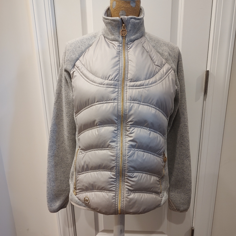 Michael Kors L grey packable down jacket with knitted arms and gold color trim.